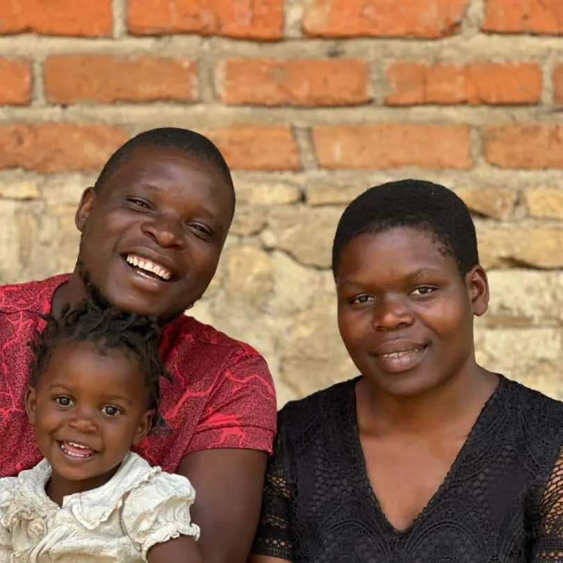 Banda and Caterin smiling, with a small child