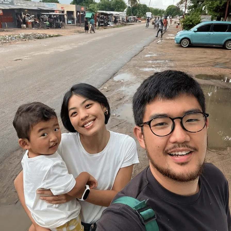 Daisuke and Victoria holding their son, on a street
