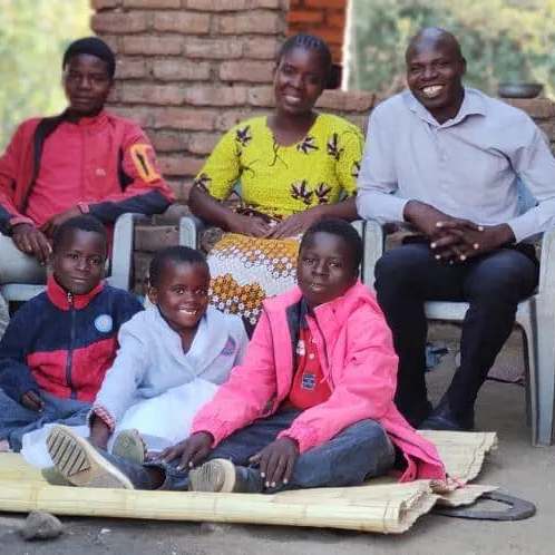 Lemson and Mwaiwawo sitting with their family